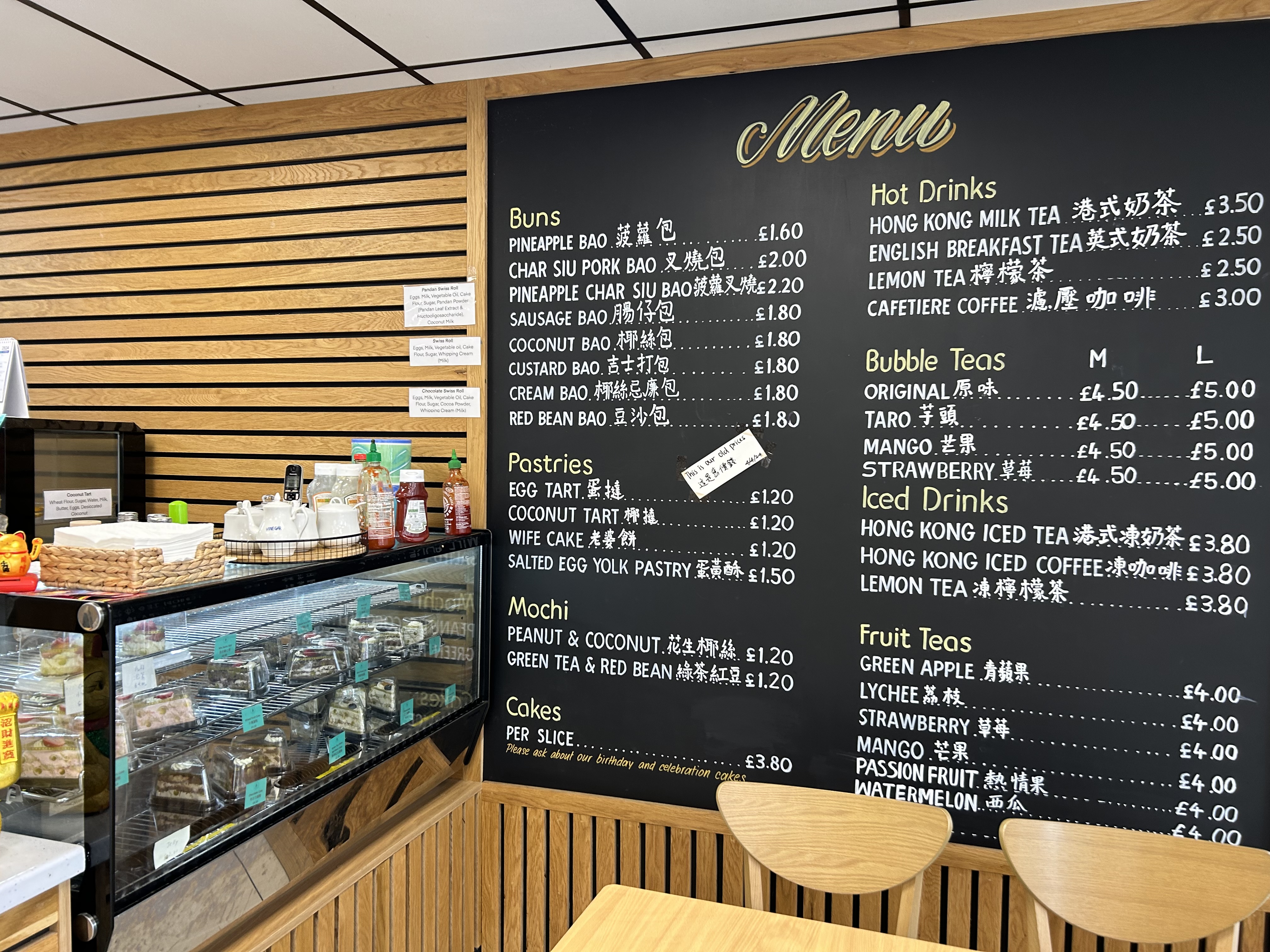 an image that shows the desserts in the display window and on the sign a large blackboard which has the menu on it