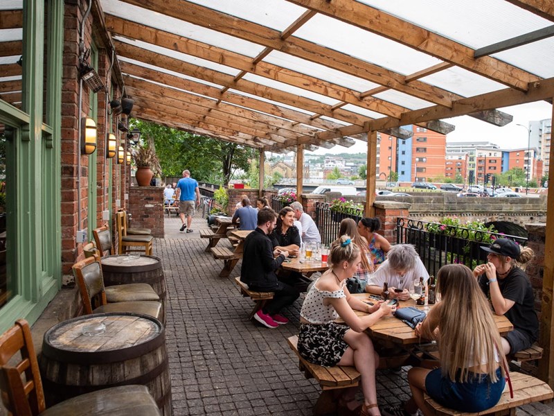 People drinking on the outdoor terrace at The Riverside Kelham.